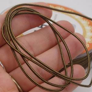 Detail of 1.4mm black and gold braided cord with spiral texture for jewelry making
