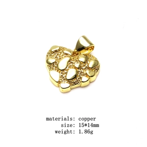 Macrodetaill van een 15x14mm koperen hartvormige hanger met vergulde nugget-textuur