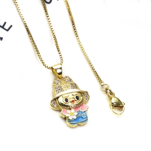 Detail der goldenen Box-Kette und Cartoon-Mädchen-Anhänger mit Zirkonia und Emaille-Finish