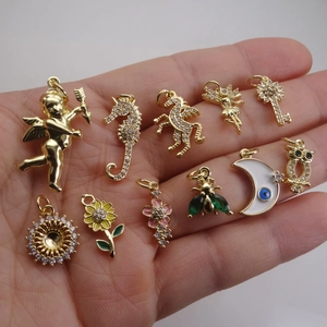 Surtido de dijes dorados con circonitas que incluyen caballito de mar, ángel y flores