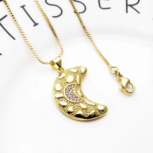 Macro detail van de halve maan hanger met hartreliëf en zirkonia aan een box ketting