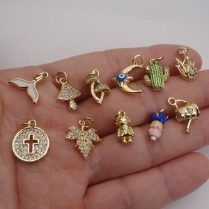 Set de 11 colgantes de oro y circón con formas variadas como hongo, luna y cactus