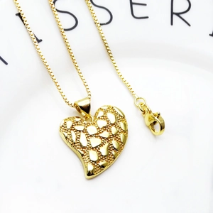 Detail van gouden hart hanger met gehamerde textuur en stevige box ketting sluiting