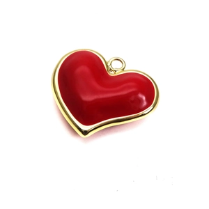 Detail of red enamel heart pendant with gold metal edges for jewelry making