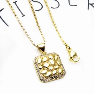 Macro-opname van de gouden vierkante hanger met zirkonia-rand aan een venetiaanse ketting