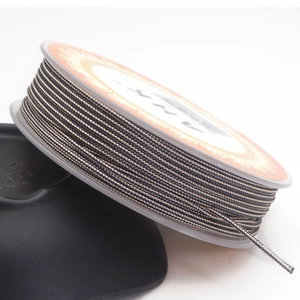 Macro detail of dual-color 1.4mm braided cord on grey spool for DIY jewelry making
