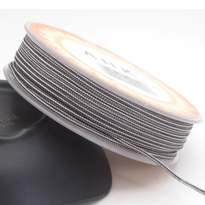 Macro shot of 1.4mm dark grey braided cord with white dots on professional plastic spool