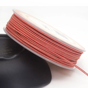 Detail of red and white braided 1.4mm cord on spool for DIY jewelry making