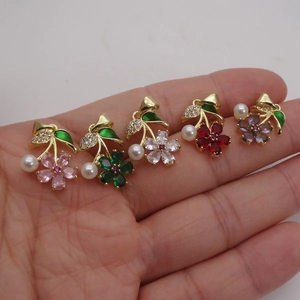 Zirconia flower petal pendant necklaces in pink green and red held in hand for scale