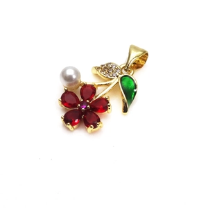 Macro detail of gold-plated flower pendant with red zircon petals and white pearl
