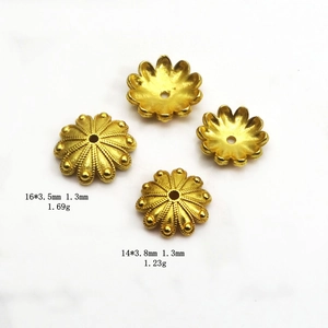 Détail macro d'espaceurs de perles fleur dorés avec texture radiale pour bijoux DIY