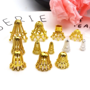 Golden and silver flower bead caps for DIY jewelry making displayed on a ceramic tray