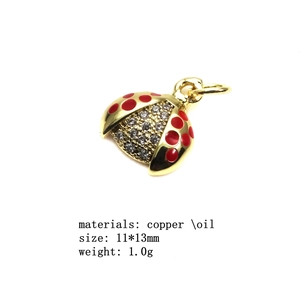 Detailed view of ladybug charm with red enamel, zircons, and gold-plated copper finish