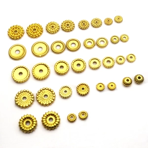 Flat lay of assorted gold-plated spacers in various geometric shapes for DIY jewelry