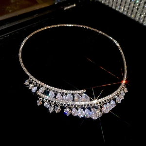 Gros plan d'un ras du cou étincelant en zircons avec franges gouttes sur velours noir.