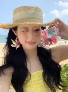 Close-up of vibrant multi-colored flower petal C-shaped earrings on a model