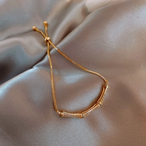 Detail view of gold bamboo knot bracelet with pavé-set stones and adjustable sliding clasp