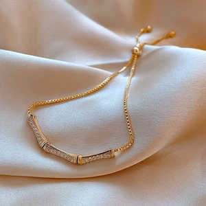 Detailed view of a gold-toned bamboo-shaped bracelet with sparkling pavé-set stones.