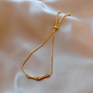 Detailed view of elegant golden bamboo knot bracelet with sparkling cubic zirconia inlay