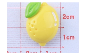 Makroaufnahme der 2,3 cm gelben Zitronen-Resin-Anhänger auf weißem Messpapier