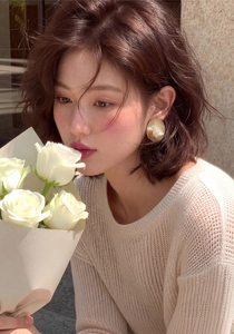 Primo piano di una modella con orecchini di perle d'oro vintage francesi e rose