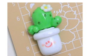 Dettaglio macro di un ciondolo cactus in resina con un sorriso per decorazioni fai-da-te