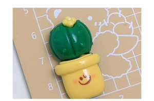 Dettaglio di un simpatico cactus a cartone animato in un vaso giallo accessorio in resina fai da te