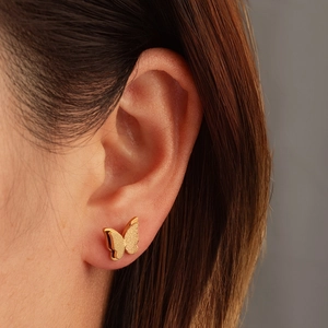 Detailaufnahme eleganter goldener Schmetterlings-Ohrstecker mit matter und polierter Struktur