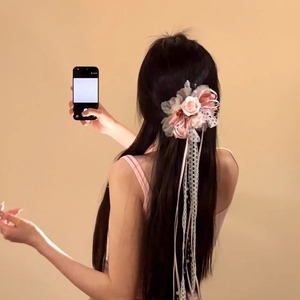 Vista dettagliata di un fermaglio per capelli con fiori in chiffon rosa e pizzo su una modella