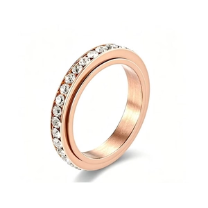 Detailed macro view of a rose gold spinner ring featuring a single row of sparkling clear crystals