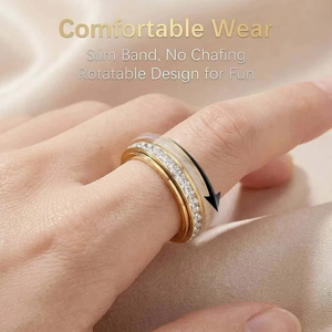 Close-up of a gold rotatable stainless steel ring with elegant rhinestones worn on a finger