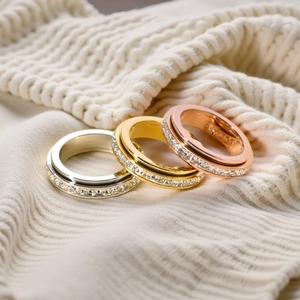 Macro view of three spinning titanium steel rings in gold, silver, and rose gold with crystals