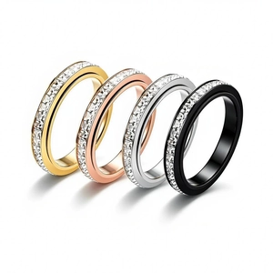 Macro detail of four single-row crystal spinner rings in gold, silver, rose gold and black