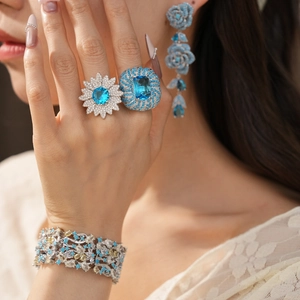Primo piano di un set di gioielli vintage con anelli e orecchini in zirconia blu a fiori