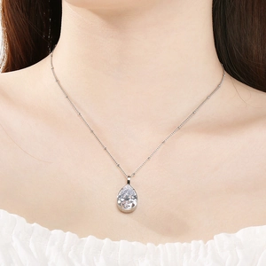 Vista dettagliata di un'elegante collana con pendente in cristallo a goccia d'argento su catena