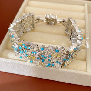 Vista dettagliata di un braccialetto vintage in argento con zirconi blu e turchese in un vassoio.