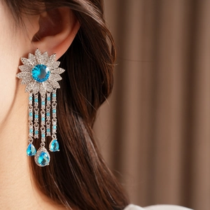 Dettaglio raffinato di orecchini vintage con fiori in zircone blu e nappe a goccia