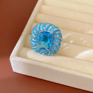 Primo piano di un anello vintage con zircone blu e perline turchesi in portagioie