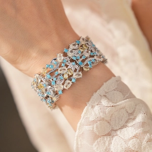 Dettaglio di un ampio bracciale in stile vintage con zirconi blu e gialli
