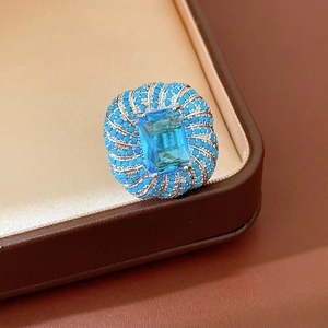 Dettaglio di un anello vintage con zircone blu e perline turchesi in scatola