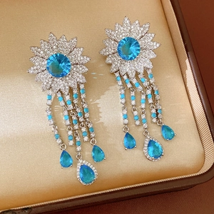 Primo piano di orecchini vintage con zirconi blu e nappe di gocce d'acqua lucenti.