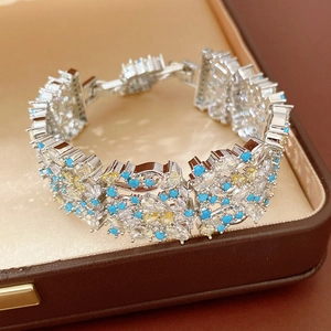 Vista dettagliata di un raffinato bracciale vintage con zirconi blu e motivi floreali.