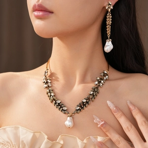 Macro view of vintage crystal leaf wheat ear necklace and earring set with pearls