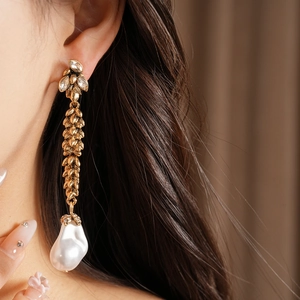 Close-up of vintage wheat ear drop earring with large baroque pearl and crystals