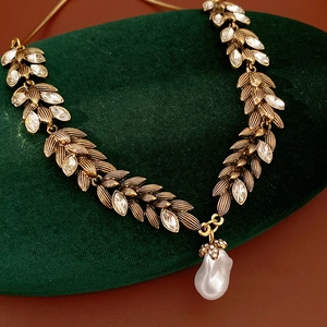 Macro detail of vintage wheat leaf necklace with crystal inlay and a baroque pearl