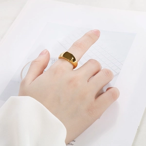 Nahaufnahme eines minimalistischen goldenen Siegelrings aus Edelstahl an einer Hand