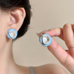 Detail view of summer dopamine blue and white drip glaze irregular earrings on ear