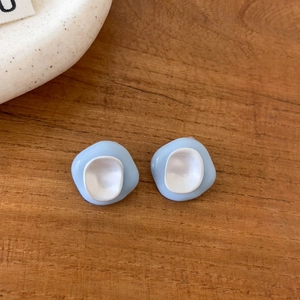 Detailed macro view of light blue and white dopamine drip oil irregular stud earrings