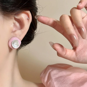 Close-up view of a pink irregular drip oil stud earring worn on an Asian model's ear