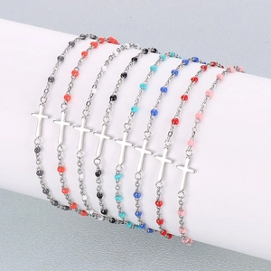 Vue détaillée de bracelets croix en acier inoxydable avec des perles de couleur variées